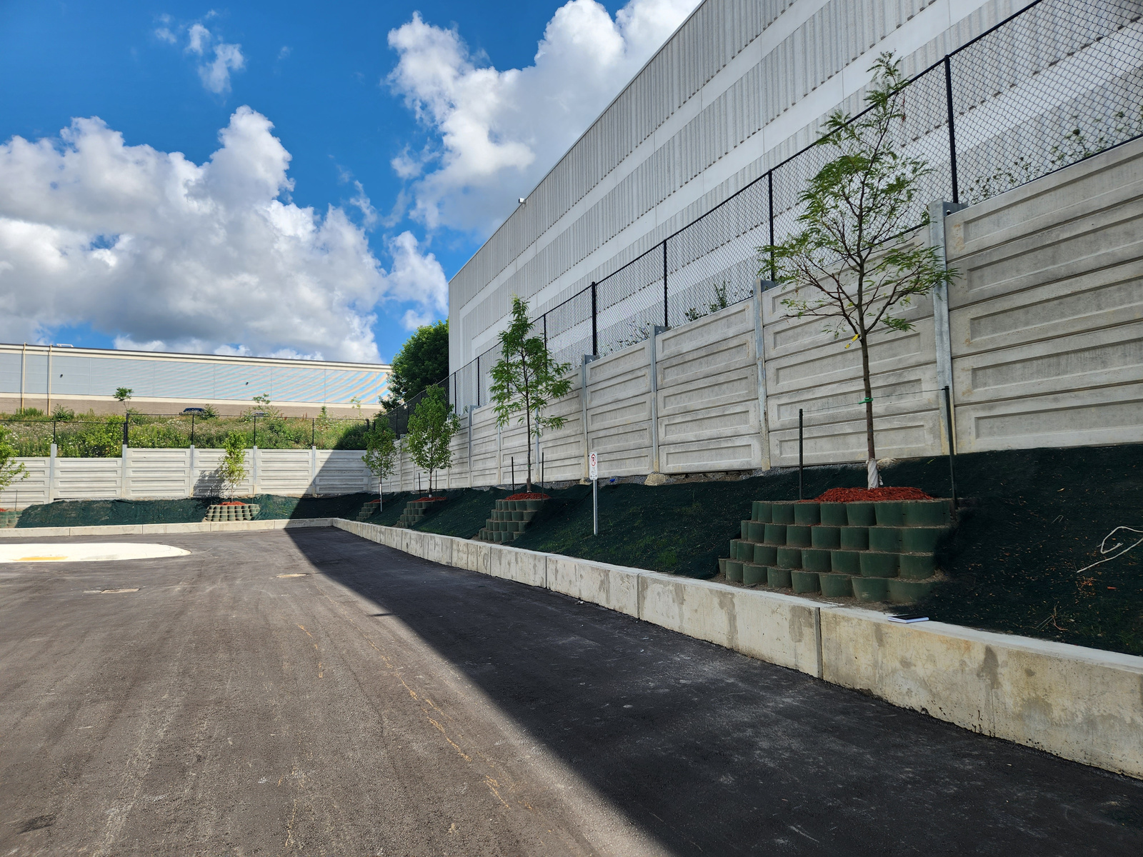 Completed vegetated MSE slope with Titan Earth Slope® – Honeycomb geocell terracing along a precast concrete wall in Richmond Hill, Ontario.